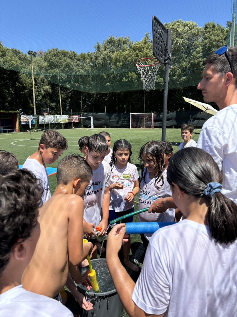 Bambini e istruttore ai giochi d'acqua al PlayGround Camp
